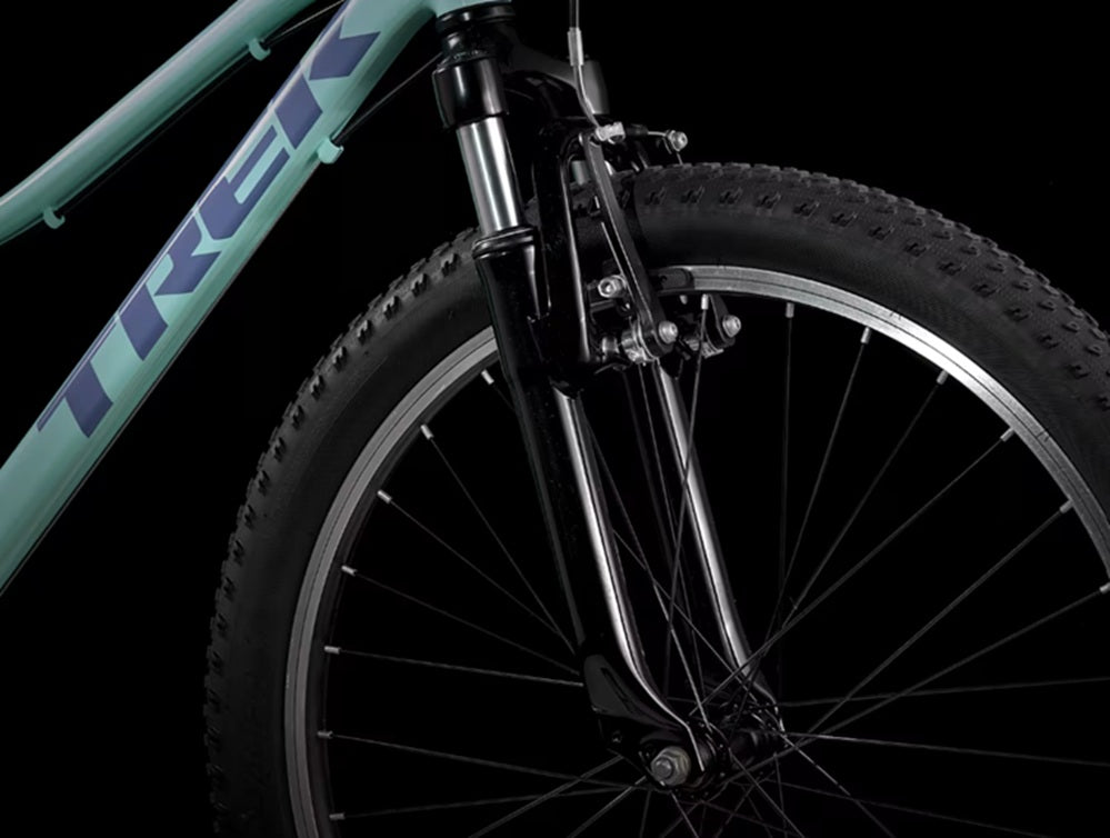 trek precaliber 24 8 speed suspension kids bike close up view of front wheel and fork